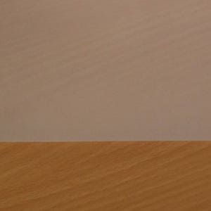 May include: A close-up of a light brown wood surface with a light gray surface above it.