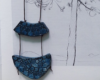 Dark blue ceramic statement necklace with imprint.