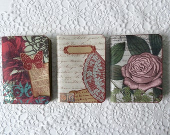 Three small scrapbook notebooks, sketch pads, travel journals, with floral patterned papers