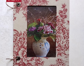 Sketchbook, drawing book, notebook with print of vase with flowers on front cover.