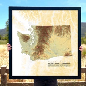 May include: A framed topographic map of Washington state, showing the state's terrain in shades of brown, green, and yellow. The map is titled "Washington" and includes a legend and copyright information.