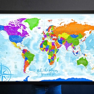 May include: A colorful world map with a blue background and a compass in the bottom left corner. The map is framed in black and has the text "Oh, the places you will go!" in the bottom center.