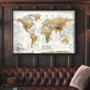 May include: A framed world map with a compass rose in the lower left corner. The map is in a vintage style with a brown and beige color scheme. The map is hanging on a dark wood wall.