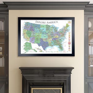 May include: A framed map of the United States with the title "Explore America". The map is in a black frame and is hanging on a wall above a fireplace.