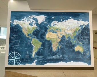 Può includere: Una mappa del mondo blu con masse terrestri verdi e caratteristiche topografiche marroni. La mappa è circondata da un oceano blu con etichette di testo bianche. Il testo in fondo alla mappa recita "The World Dream Explore Discover".
