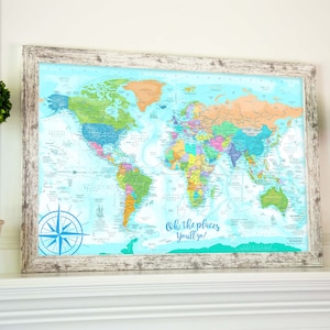 May include: A framed world map with a light blue background and colorful countries. The map is surrounded by a white distressed wood frame. The text "Oh, the places you'll go!" is printed at the bottom of the map.