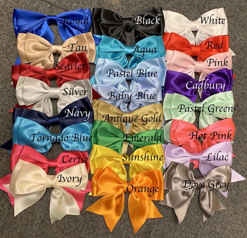 May include: A collection of 20 satin ribbon bows in various colors, including royal blue, black, white, tan, red, aqua, scarlet, pink, pastel blue, silver, navy, antique gold, tornado blue, emerald, hot pink, cerise, sunshine, lilac, ivory, and orange. The bows are arranged in rows and labeled with their corresponding colors.