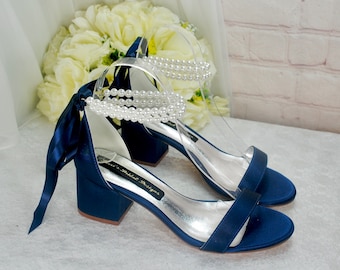 Zapatos de dama de honor de satén azul marino con tacón bajo y tiras de perla en el tobillo, color personalizado.
