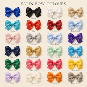 May include: A grid of twenty-four satin bows in various colors, each labeled with its name below. The colors include royal, black, white, tan, aqua, red, scarlet, pastel blue, pink, silver, baby blue, cadbury, navy, antique gold, pastel green, tornado blue, emerald, hot pink, cerise, sunshine, lilac, ivory, orange, and dove grey.