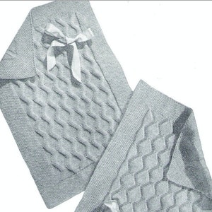 Peut inclure: Deux couvertures pour bébé en tricot gris avec un motif en losange. Une couverture a un ruban de satin blanc noué en un nœud.