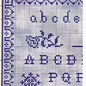 Könnte beinhalten: Nahaufnahme eines blau-weißen Kreuzstichmusters. Das Design umfasst Buchstaben, florale Motive und dekorative Bordüren. Die Buchstaben "abode" sind sichtbar, zusammen mit anderen Buchstabenmustern.