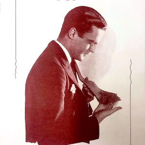 Puede incluir: Una imagen vintage en blanco y negro de un hombre con traje ajustándose la corbata. La imagen es de un libro titulado "Hemingway Tie Book" con el texto "Number One" y "Published by The H. K. H. Silk Company of New York, Inc. Price, Ten Cents".