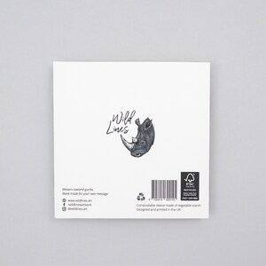 May include: A white greeting card featuring a detailed black and white illustration of a rhinoceros head. The card has the text "Wild Lines" and includes the website and social media handles. The card is designed and printed in the UK.