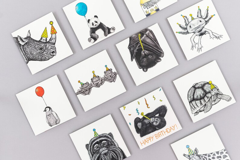 May include: A set of 10 greeting cards featuring various animals wearing party hats. The cards are all square and have a white background. The animals include a rhino, a panda, a bat, a frog, a turtle, an axolotl, a monkey, a penguin, a monkey, and a giraffe.