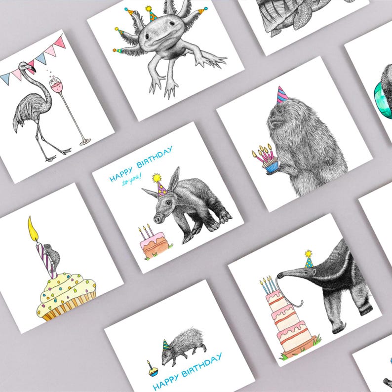 May include: A collection of square birthday cards featuring whimsical animal illustrations. The cards showcase various animals, including an axolotl, aardvark, and anteater, each adorned with party hats and cakes. The phrase "Happy Birthday to you!" is printed on some cards.