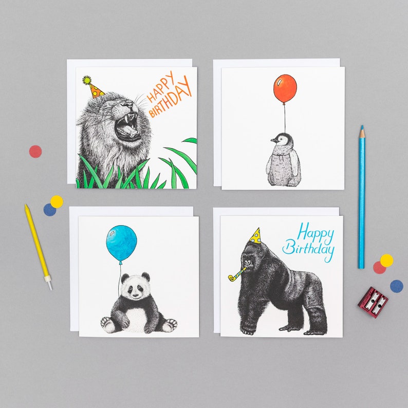 May include: Set of four greeting cards featuring animal illustrations. The cards are white with black ink drawings of a lion, a penguin, a panda, and a gorilla. Each card has a birthday message and a party hat on the animal.