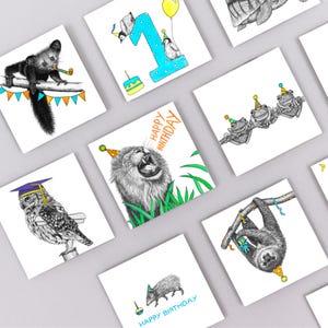 May include: Square greeting cards with animal illustrations, including a lion, owl, and sloth, each wearing a party hat. Some cards have "Happy Birthday" text. The cards are white with black and color illustrations.
