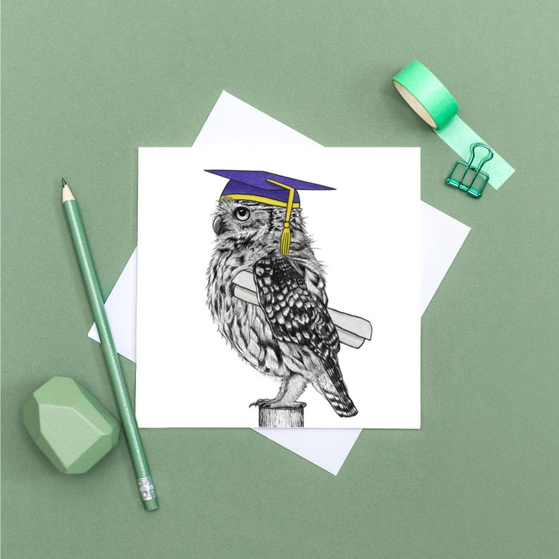 May include: A graduation-themed greeting card featuring a detailed illustration of an owl wearing a purple and gold graduation cap and holding a diploma. The owl is perched on a wooden post. The card is on a white background.