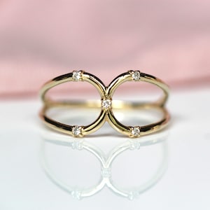 May include: A gold ring with a double-loop design and five small diamonds.