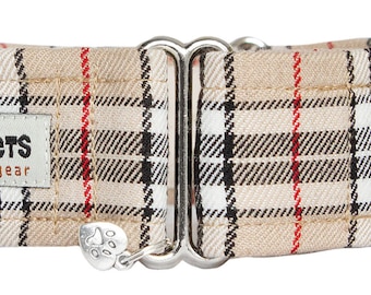 Puede incluir: Un collar para perro de color beige con estampado de cuadros negros, blancos y rojos, con una hebilla plateada y un dije plateado con una huella de pata. El collar tiene una etiqueta que dice "Noddy & Sweets handmade petgear".