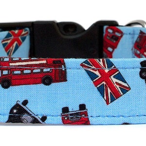 Könnte beinhalten: Hellblaues Hundehalsband mit einem Muster aus roten Doppeldeckerbussen, schwarzen Taxis und Union-Jack-Flaggen. Das Halsband hat eine schwarze Kunststoffschnalle und einen silbernen Metall-D-Ring.