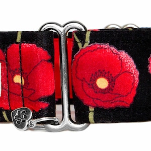 May include: Black dog collar with a red poppy floral print and silver hardware. The collar has a silver buckle and a silver D-ring. The collar is labelled "Rody & Sweets hand made petgear".