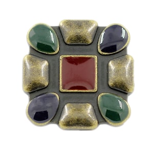 May include: A brass-colored metal square with a red, green, and blue enamel design. The square is decorated with eight oval-shaped stones.