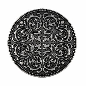 Puede incluir: Un botón de metal plateado con un diseño floral decorativo. El botón es redondo y tiene un diseño en relieve.