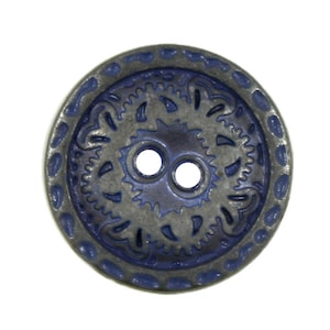 May include: A two-hole blue and silver button with a decorative design. The button has a raised, textured border and a central design with a floral motif.