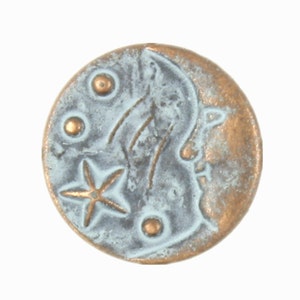 May include: A round, copper-colored coin with a blue-grey patina. The coin features a star, a crescent moon, and three small circles.