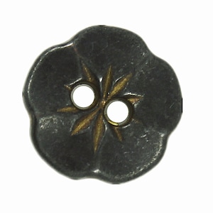 May include: A black metal button with a gold star design and two holes. The button has a slightly rounded, flower-like shape.