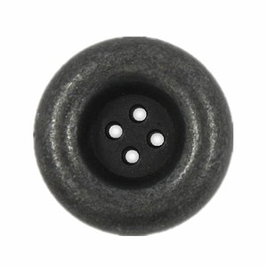May include: A large, round, silver-coloured button with four black holes in the centre.