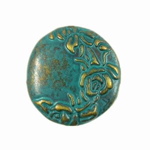 May include: A round, teal-colored button with a raised design of gold roses. The button has a distressed, antique look.