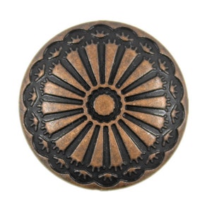 Può includere: Un bottone rotondo di colore rame con un design nero intricato. Il design presenta un cerchio centrale con linee radianti e un bordo decorativo.