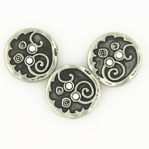 May include: Three silver-toned metal buttons with a black and white swirl design. Each button has three white dots in the center.