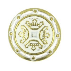 May include: A round, white button with a gold rim and a decorative design of four crowns in the centre.