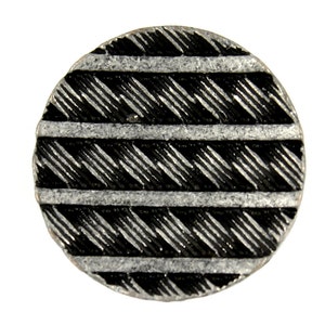 May include: A round, silver-colored button with a black and white geometric pattern. The pattern is made up of diagonal lines and horizontal stripes.