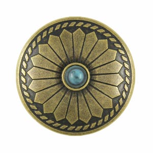 May include: A round, antique gold-toned metal button with a turquoise stone in the center. The button has a decorative design of a sunburst with a rope border.