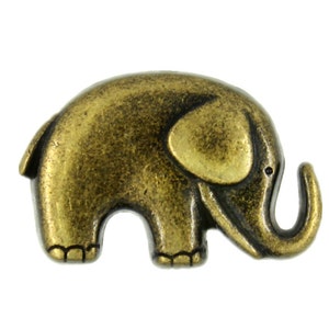 May include: A small, antique gold-toned metal elephant figurine. The elephant is standing with its trunk raised and has a detailed design.