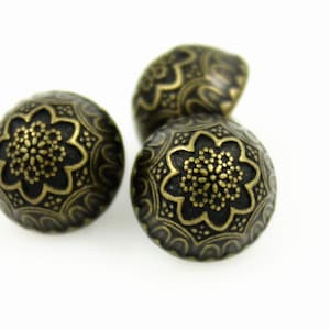 May include: Three antique gold-toned metal buttons with a decorative floral design.