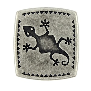 May include: A silver square-shaped metal button with a black gecko design inside a black triangle border.