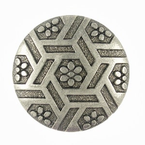 May include: A silver-toned metal button with a geometric design featuring a repeating pattern of hexagons and small flower-like shapes.