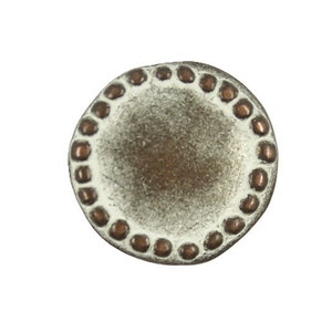 May include: A round, white button with a decorative border of small, copper-colored dots.