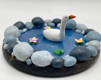 Clay Swan swimming in pond