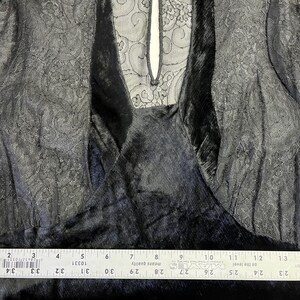 以下が含まれることがあります： 黒いベルベットのドレス、レースの袖とネックライン。 ドレスはVネックのデザインとキーホールバックが特徴です。 レースのディテールが全体的な外観にエレガントさを加えています。 ドレスは定規で測定されています。