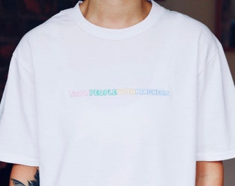 Puede incluir: Camiseta blanca con el texto "Treat People With Kindness" en colores arcoíris.