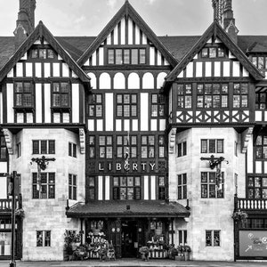 May include: A black and white photo of a building with a sign that reads "LIBERTY". The building has a Tudor style architecture with a lot of intricate details.