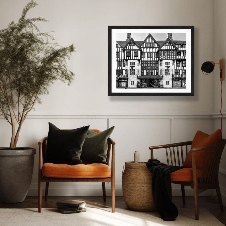 May include: Black and white photograph of a large, ornate building with a sign that reads "Liberty's". The building has a Tudor-style facade with many windows and a large entrance.