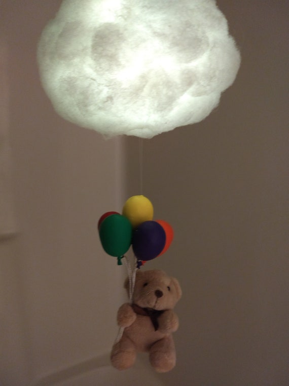 teddy bear hanging from balloons