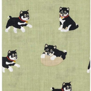 May include: A green fabric with a repeating pattern of black and white Shiba Inu dogs. Some dogs are sitting, while others are lying down.